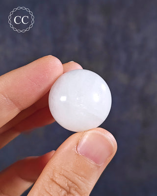 Cryolite Sphere in hand on blue background