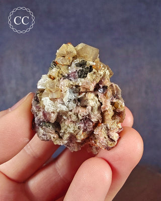 A hand holding a Crystalline Moonstone specimen from the Pili Mine in Chihuahua, Mexico. 