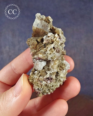 A hand holding a Crystalline Moonstone specimen from the Pili Mine in Chihuahua, Mexico. 
