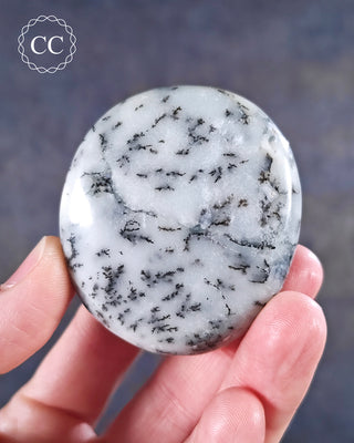 A hand holding a  Dendritic Opal | Merlinite chunky palmstone from Madagascar 