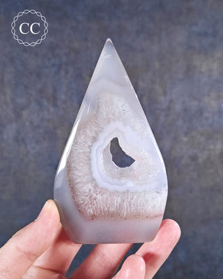 A hand holding a Druzy Agate freeform with a central druzy pocket