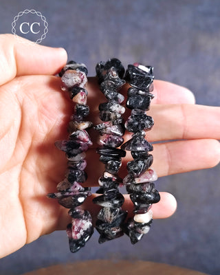 Eudialyte Bracelets on hand on blue background