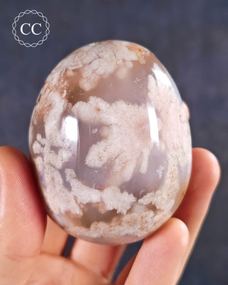 A hand holding a Flower Agate Chunky Palmstone from Madagascar