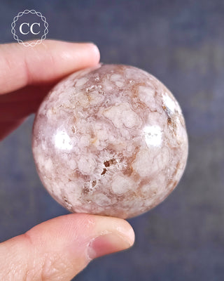 A hand holding a Flower Agate Sphere from Madagascar