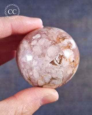 A hand holding a Flower Agate Sphere from Madagascar