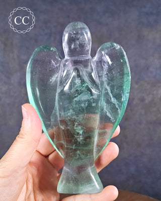 Fluorite Angel in hand on blue background