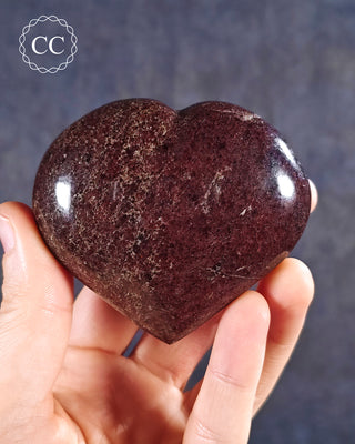 A hand holding a Garnet Heart from Madagascar