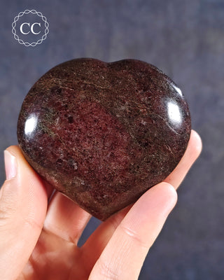 A hand holding a Garnet Heart from Madagascar