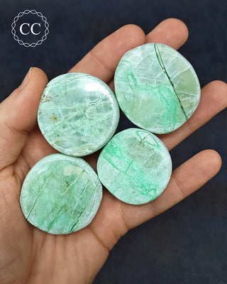 A hand holding 4 Garnierite Dragon Eggs from Madagascar