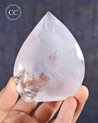 A hand holding a Girasol Dendritic Quartz Flame from Brazil 