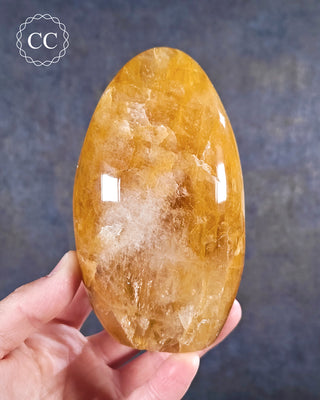 A hand holding a Golden Healer freeform from Madagascar