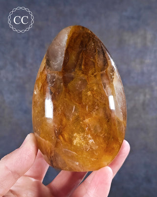 A hand holding a Golden Healer freeform from Madagascar