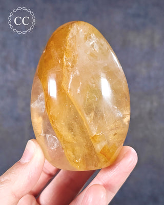 A hand holding a Golden Healer freeform from Madagascar