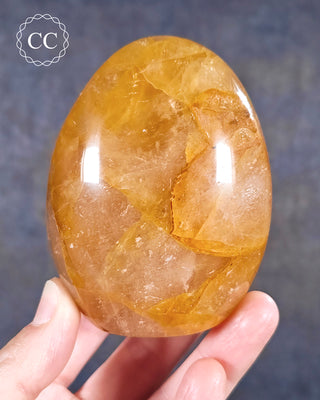 A hand holding a Golden Healer freeform from Madagascar
