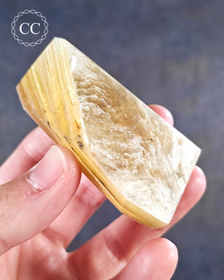 A hand holding a Golden Mica Freeform 