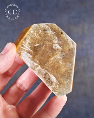 A hand holding a Golden Mica Freeform 