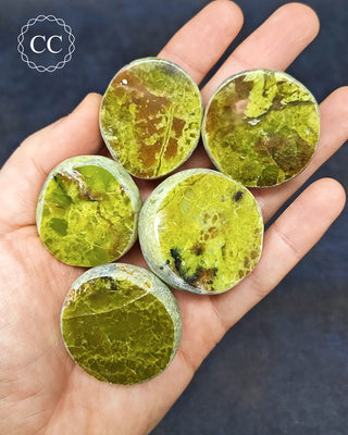 A hand holding 5 Green Opal Dragon Eggs from Madagascar