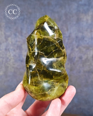 A hand holding a Green Opal Flame from Madagascar