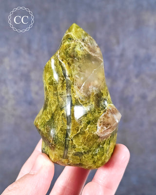 A hand holding a Green Opal Flame from Madagascar