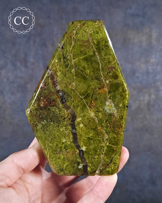 A hand holding a Green Opal Freeform from Madagascar 
