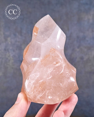 A hand holding a Hematoid Quartz Flame from Madagascar