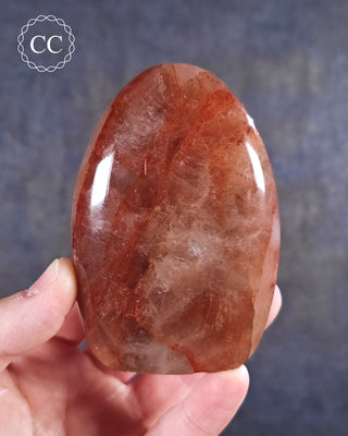A hand holding a Hematoid Quartz - Fire Quartz Freeform from Madagascar