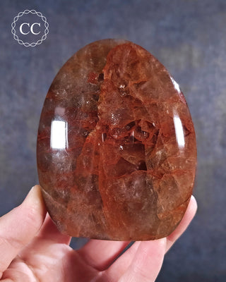 A hand holding a Hematoid Quartz - Fire Quartz Freeform from Madagascar