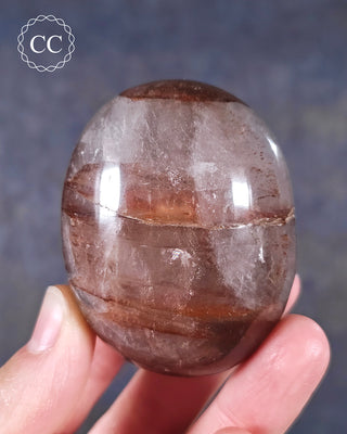 A hand holding a Hematoid Quartz Chunky Palmstone from Madagascar