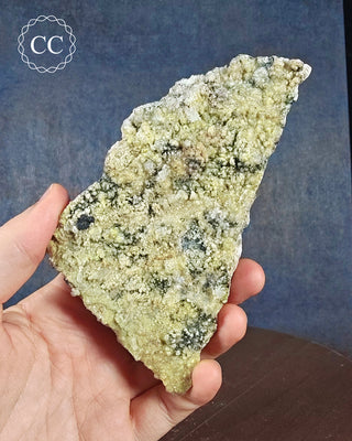 A hand holding a  UV reactive Hyalite Opal Specimen from Namibia