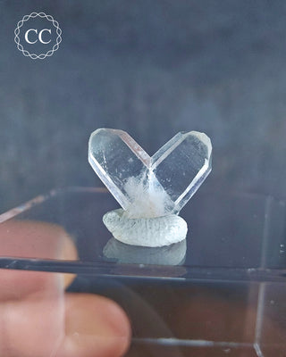 A Japan Law Twin Quartz from Namibia displayed on a clear box 