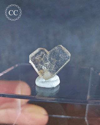 A Japan Law Twin Quartz from Namibia displayed on a clear box 