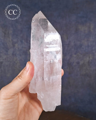 A hand holding a large Clear Quartz natural unpolished point from Brazil
