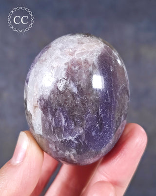 A hand holding a Lepidolite Chunky Palmstone from Madagascar