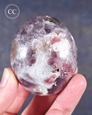 A hand holding a Lepidolite Chunky Palmstone from Madagascar