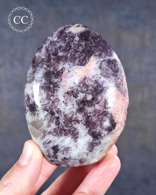 A hand holding a Lepidolite and Pink Tourmaline Freeform from Madagascar