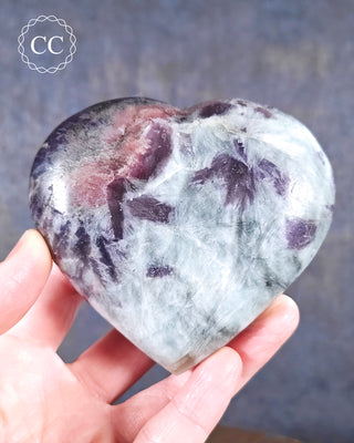 A hand holding a Lepidolite and Pink Tourmaline Heart from Madagascar 