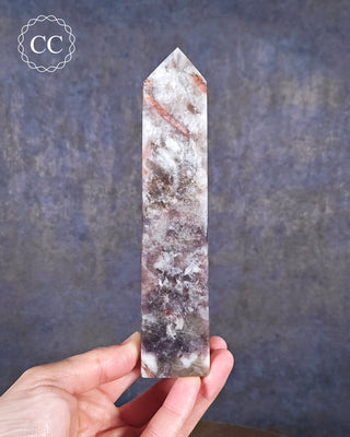 A hand holding a Lepidolite and Pink Tourmaline Tower 