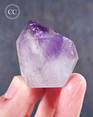 A hand holding a Madagascan Amethyst Tower