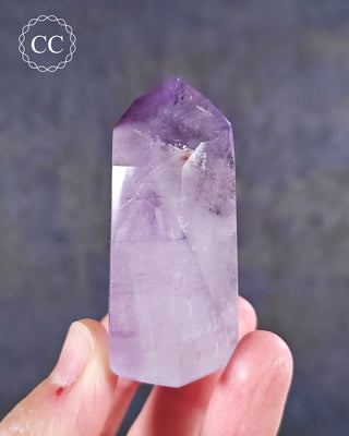 A hand holding a Madgascan Amethyst Tower