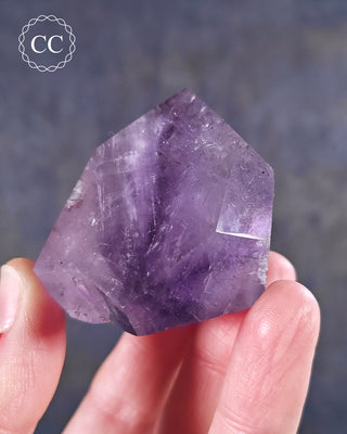 A hand holding a Madagascan Amethyst Tower