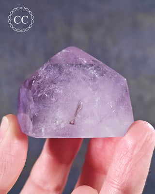 A hand holding a Madagascan Amethyst Tower