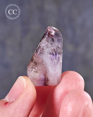 A hand holding a Madagascar Amethyst Tower