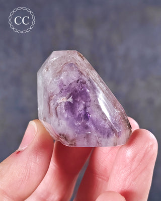 A hand holding a Madagascan Amethyst Tower