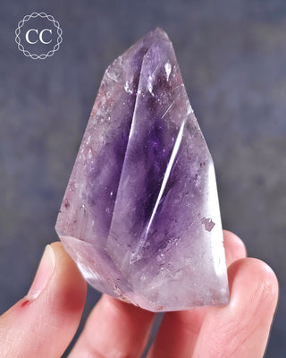 A hand holding a Madagascan Amethyst Tower