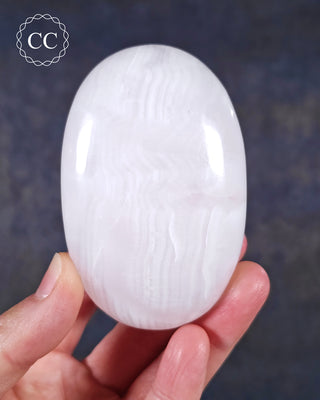 A hand holding a Mangano Calcite Chunky Palmstone from Pakistan 
