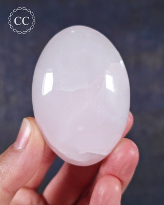 A hand holding a Mangano Calcite Chunky Palmstone from Pakistan 