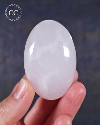 A hand holding a Mangano Calcite Chunky Palmstone from Pakistan 
