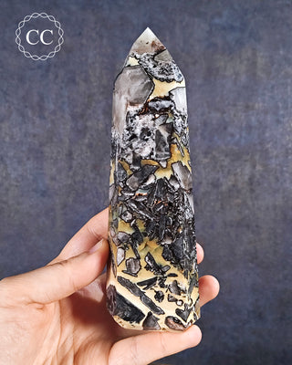 A hand holding a Mosaic Quartz Tower from Brazil