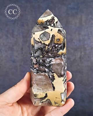 A hand holding a Mosaic Quartz Tower from Brazil 