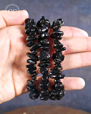 Nuummite Chunky Bracelets on hand on blue background